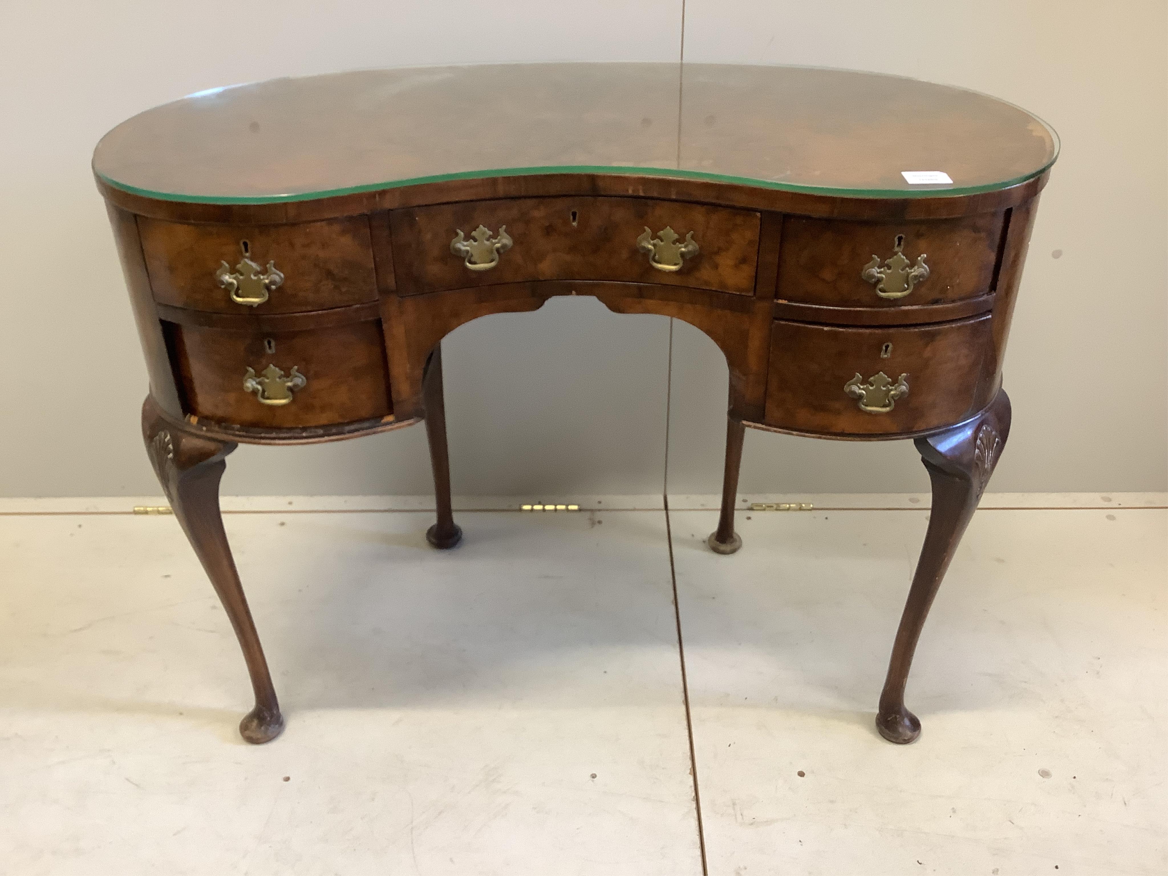 A Queen Anne Revival walnut kidney shaped kneehole dressing table, width 101cm, depth 56cm, height 76cm. Condition - fair